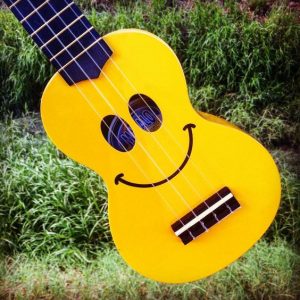 a yellow ukulele with a smile face