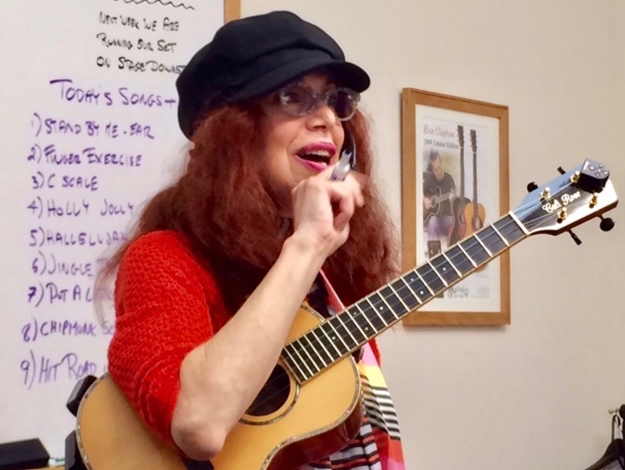 A woman with a microphone and a ukulele