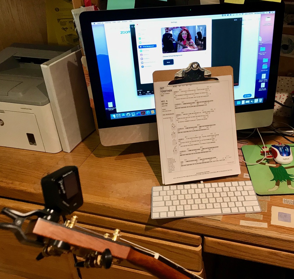 desk with a computer, a clipboard with music